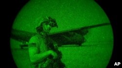 FILE - U.S. Army soldier providing security seen through a night-vision device, June 12, 2020, at an undisclosed location in Somalia. 