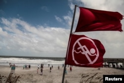 Red flags to indicate that the ocean has a high tide and locals should not be swimming due to danger are seen at Jacksonville Beach before Hurricane Dorian, in Jacksonville, Florida, Sept. 3, 2019.