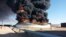 Smoke and flame rise from an oil storage tank that was set on fire amid fighting between rival factions at Ras Lanuf terminal, Libya, in this handout picture released June 18, 2018. 