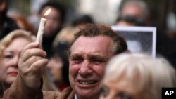 A man cries as he holds up a candle on the 25th anniversary of the bombing of the AMIA Jewish center that killed 85 people in Buenos Aires, Argentina, Thursday, July 18, 2019.