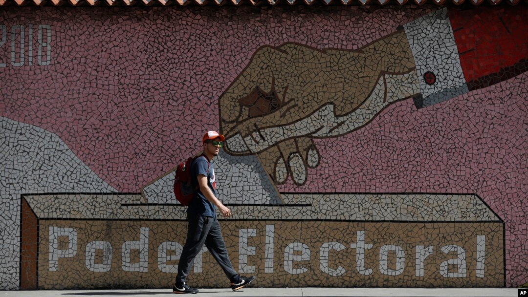Un hombre camina frente a un mural del Poder Electoral en Caracas, el 31 de julio de 2024.