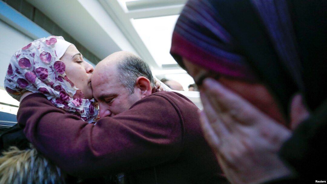 Pengungsi Suriah, Baraa Haj Khalaf (kiri), mencium ayahnya, Khaled, sementara ibunya, Fattoum (kanan), menangis ketika mereka tiba di Bandara Internasional O'Hare, di Chicago, Illinois, Amerika Serikat, 7 Februari 2017. (Foto: Kamil Krzaczynski/Reuters)