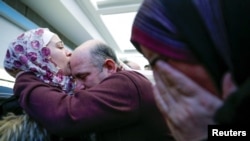 Pengungsi Suriah, Baraa Haj Khalaf (kiri), mencium ayahnya, Khaled, sementara ibunya, Fattoum (kanan), menangis ketika mereka tiba di Bandara Internasional O'Hare, di Chicago, Illinois, Amerika Serikat, 7 Februari 2017. (Foto: Kamil Krzaczynski/Reuters)