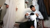 یک جوان در مراسم عمامه گذاری مدرسه علمیه امام صادق در تایباد خراسان، تمرین می کند چطور عمامه خود را ببندد.<br />
عکس: محمدجواد مشهدی، فارس