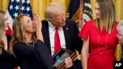 Valerie Nessel (2-L), accompanied by family members, blows a kiss to the sky as she accepts the Medal of Honor from President Donald Trump (C) for her husband, Air Force Tech. Sgt. John Chapman, at the White House, in Washington, Aug. 22, 2018.