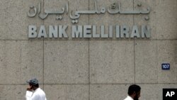 FILE - Two men pass by the main branch of Bank Melli Iran, the National Bank of Iran in Dubai, United Arab Emirates, July 1, 2008. 