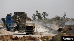 FILE - A truck is packed with crushed granite at a mining plant in Zamfara, Nigeria, April 21, 2016.