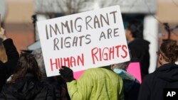 FILE - A protester holds up a placard during a rally in support of Jeanette Vizguerra, a Mexican woman seeking to avoid deportation from the United States, outside the Immigration and Customs Enforcement office in Centennial, Colorado, Feb. 15, 2017.