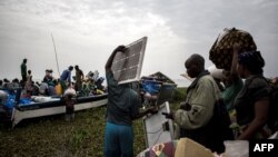 Des personnes embarquent dans des pirogues sur le lac Albert pour fuir les violences en Itrui vers l'Ouganda à Tchomia, le 5 mars 2018.