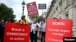 Pro-Brexit and anti-Brexit protesters with placards stand together at Westminster in London, Britain, Sept. 3, 2019. 
