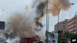 Smoke and debris fill the sky seconds after a car bomb explodes alongside firemen responding to an initial car bomb that had exploded five minutes earlier, in Abuja, Nigeria, 01 Oct 2010