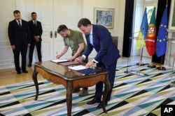 Presiden Ukraina Volodymyr Zelenskyy dan Perdana Menteri Portugal Luis Montenegro (kanan), menandatangani perjanjian bilateral di Istana Sao Bento, kediaman resmi perdana menteri, di Lisbon, Selasa, 28 Mei 2024. (Jose Sena Goulao/Pool via AP)