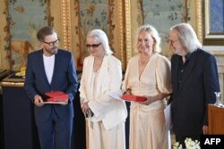 Anggota grup musik ABBA: Björn Ulvaeus, Anni-Frid Lyngstad, Agnetha Fältskog dan Benny Andersson saat menerima penghargaan "Vasa Kerajaan" dalam upacara di Istana Kerajaan Stockholm.