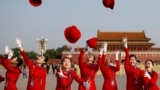 Ushers throw their hats in the air as they pose for photographers at the Tiananmen Square before the start of the closing session of the 19th National Congress of the Communist Party of China, in Beijing, China October 24, 2017.