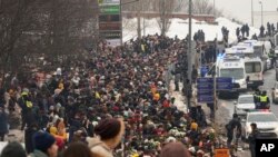 FILE—Police, right, observe as people walk towards the Borisovskoye Cemetery for the funeral ceremony of Russian opposition leader Alexei Navalny, in Moscow, Russia, March 1, 2024. 