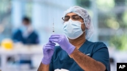 A technician prepares a Pfizer vaccine in the pharmacy area of the newly opened COVID-19 Vaccination Centre in Sydney, Australia, Monday, May 10, 2021. (James Gourley/Pool Photo via AP)