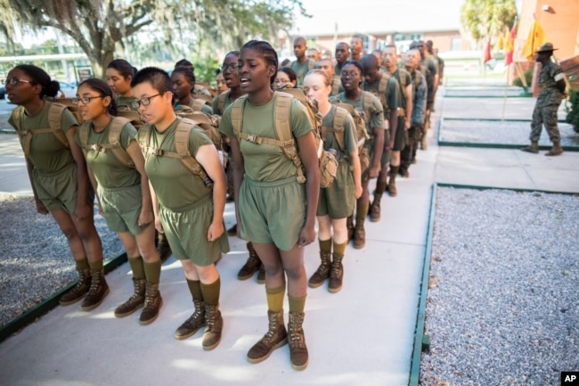 A group of female U.S. Marine Corps recruits stand in platoon order outside the Marine Corps Recruit Depot pool after swim training, Wednesday, June 28, 2023, in Parris Island, S.C. (AP Photo/Stephen B. Morton)