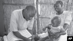 Chisomo Boxer examines Anthony’s feet to check for edema. Chisomo was trained by Save the Children to deliver primary health care in an isolated rural community in Malawi. Anthony’s mother Mercy is grateful that she does not have to walk 14 miles across r