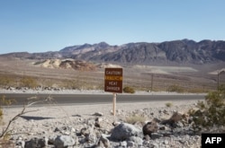 FILE - A heat advisory sign is shown along US highway 190 during a heat wave in Death Valley National Park in Death Valley, California, on July 16, 2023. (Photo by Ronda Churchill / AFP)