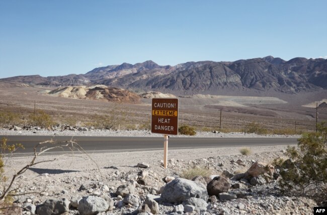 FILE - A heat advisory sign is shown along US highway 190 during a heat wave in Death Valley National Park in Death Valley, California, on July 16, 2023. (Photo by Ronda Churchill / AFP)