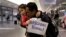Thy Chea, of Lowell, Mass., center right, originally of Cambodia, hugs his daughter on his arrival at Boston's Logan Airport, Wednesday, Feb. 26, 2020, after getting his green card reinstated last year. 