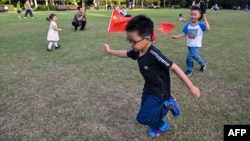 孩子們手持中國國旗在上海黃浦區的復興公園玩耍。 （2024年9月30日）