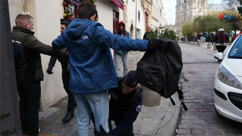 Agentes de la policía francesa realizan controles de seguridad al público cerca de la catedral de Notre-Dame de París, antes de su ceremonia oficial de reapertura.