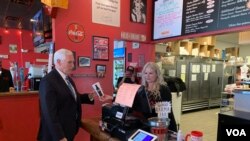 U.S. Vice President Mike Pence orders lunch from Beth Steele, owner of Beth’s Burger Bar in Orlando, Fla., May 20, 2020. (Steve Herman/VOA) 