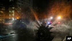Workers use sprayers pulled by tractors to disinfect the city streets as a precautionary measure against COVID-19 in Santiago, Chile, April 1, 2020. 