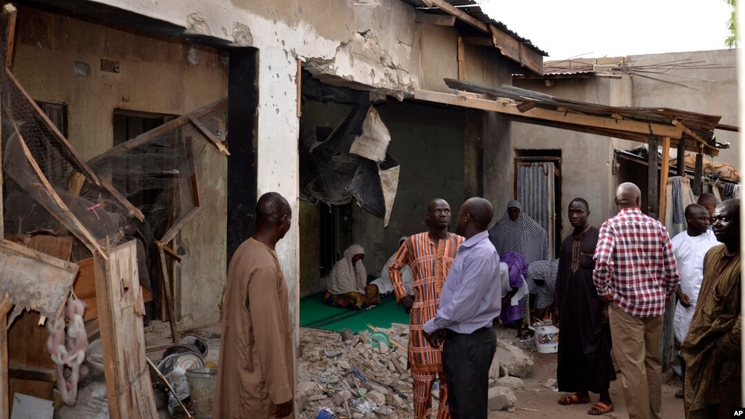 Warga memeriksa bangunan yang hancur akibat serangan Boko Haram di Maiduguri, Nigeria (31/5). Boko Haram kembali menyerang Maiduguri, Selasa 2/6.