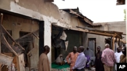 尼日利亚迈杜古里市居民正在查看被伊斯兰国武装炸坏的房屋（2015年5月31日）