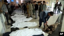 지난 5월 아프가니스탄 하자라족 집단 거주지 여학교에서 발생한 폭탄 테러 직후 주민들이 사체를 수습하고 있다.