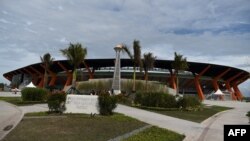 Para pengunjung (tengah) berfoto di samping stadion di New Clark City saat SEA Games, di Kota Capas, Provinsi Tarlac, utara Manila, 2 Desember 2019. (Foto: AFP)