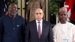 FILE—Omar Touray, left, president of the ECOWAS Commission, welcomes Mauritanian President Mohamed Ould El-Ghazouani , center, for the ECOWAS meeting in Abuja, Nigeria. August 10, 2023.