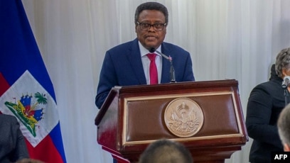 there is a man standing at a podium with a microphone