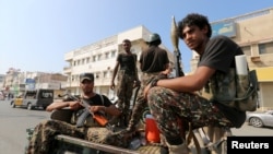 FILE - Houthi rebels patrol a street where pro-Houthi protesters demonstrated against the Saudi-led coalition in Hodeidah, Yemen.