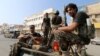 FILE - Houthi militants patrol a street where pro-Houthi protesters demonstrated against the Saudi-led coalition in Hodeida, Yemen, Dec. 10, 2018.