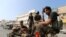 FILE - Houthi rebels patrol a street where pro-Houthi protesters demonstrated against the Saudi-led coalition in Hodeidah, Yemen.
