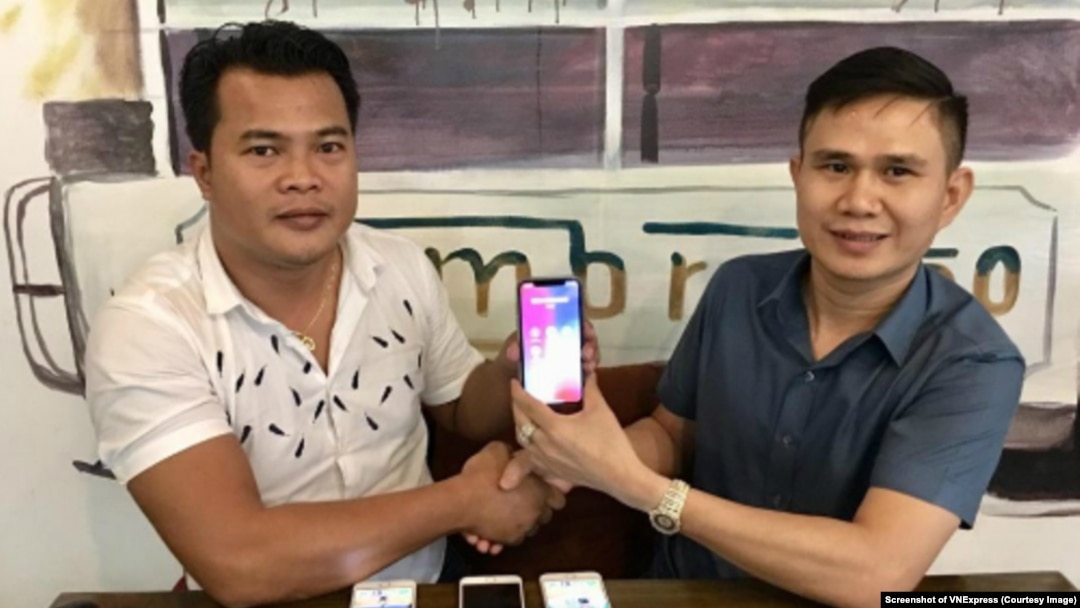 Thái Minh Phương (trái) và Mạnh Tài cùng cầm chiếc điện thoại có 'siêu SIM' mang 8 số 9. Số điện thoại này được bán với giá 1 triệu USD. (Ảnh chụp màn hình VNExpress)