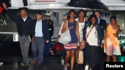 El presidente Barack Obama (izquierda) y su familia se preparan para abordar el avión presidencial para regresar a Washington desde Massachusetts.