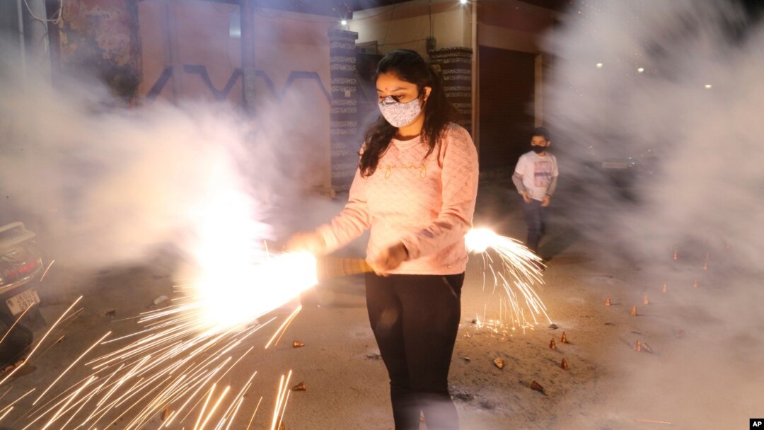 Seorang anak perempuan bermain kembang api dalam perayaan festival cahaya, Diwali, di Jammu, India, Sabtu, 14 November 2020.