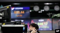 A currency trader watches computer monitors at the foreign exchange dealing room in Seoul, South Korea, April 16, 2020.