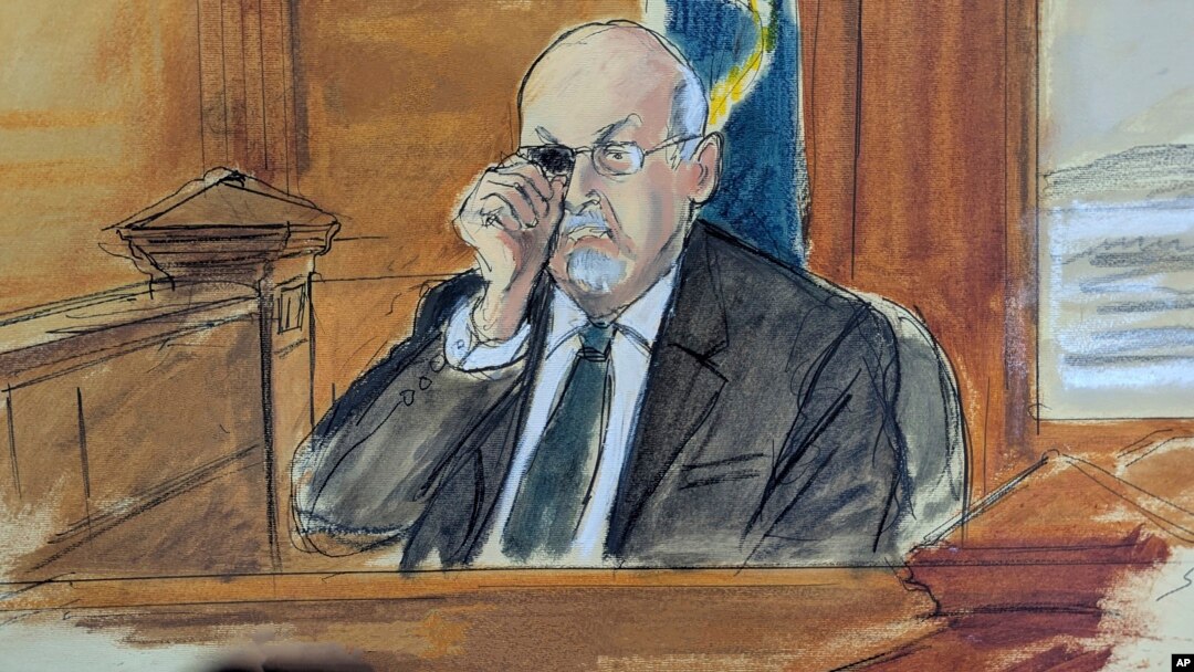 In this courtroom sketch, Salman Rushdie testifies on the witness stand, during the trial of Hadi Matar, Feb. 11, 2025 in Mayville, N.Y. showing how he was stabbed in the eye, when he was attacked in 2022. 