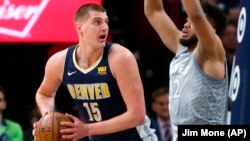 Nikola Jokić (Denver) u duelu sa Karl-Entonijem Taunsom (Minesota) na utakmici 11. aprila 2018. godine u Mineapolisu (Foto: AP/Jim Mone) 