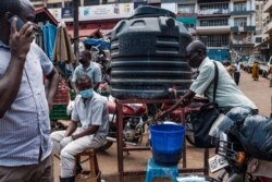 People are required to wash their hands before entering Nakasero market in Kampala, April 1 2020.