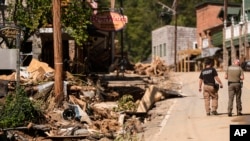 Dos agentes del sheriff caminan por la calle principal después del paso del huracán Helene, el miércoles 2 de octubre de 2024, en Chimney Rock Village, Carolina del Norte