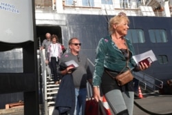 Passenger disembark from the MS Westerdam at the port of Sihanoukville, Cambodia, Feb. 15, 2020.