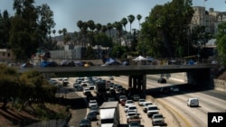 FILE - In this July 7, 2021, file photo homeless encampments are installed on an overpass of the CA-101 Hollywood freeway in Los Angeles. The share of Americans living in poverty rose slightly as the COVID pandemic shook the economy last year, but…