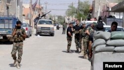 Shi'ite volunteers are seen with their weapons during an intensive security deployment to fight against militants of the Islamic State in the town of Tuz Khurmatu, Iraq, Aug. 31, 2014. 