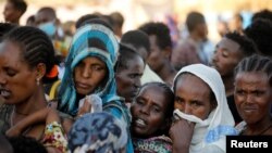 FILE - Ethiopian refugees line up for supplies at the Um Rakouba refugee camp, which houses refugees fleeing the fighting in the Tigray region, on the Sudan-Ethiopia border in Sudan, Nov. 29, 2020. 